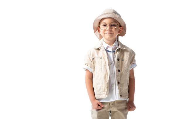 Vorderansicht eines lächelnden Forscherkindes mit Hut und Brille, das isoliert auf weiß in die Kamera blickt - Foto, Bild