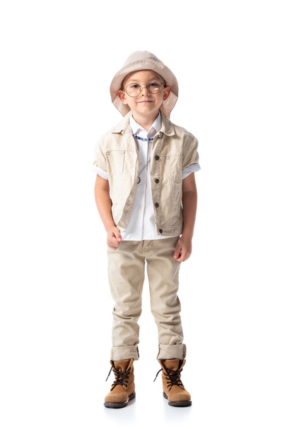 full length view of smiling explorer child in hat and glasses looking at camera isolated on white - Foto, imagen