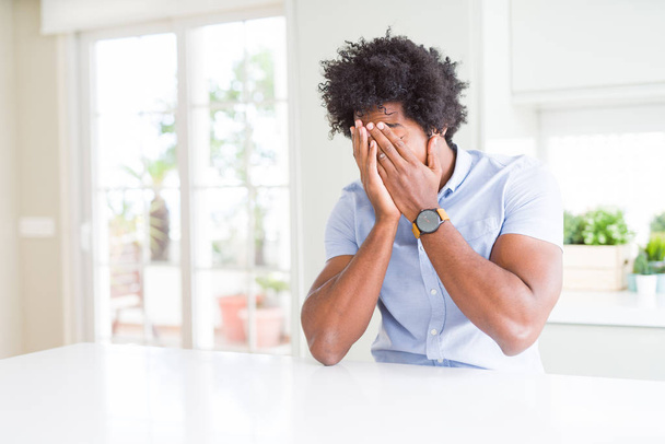 Афро-американский бизнесмен с грустным выражением лица, закрывающим лицо руками во время плача. Концепция депрессии
. - Фото, изображение