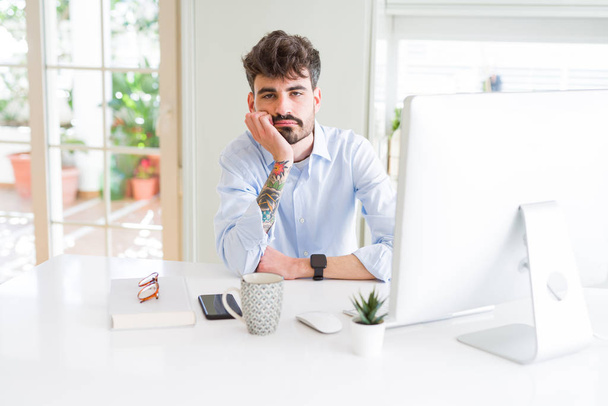 Young business man working using computer thinking looking tired and bored with depression problems with crossed arms. - Photo, Image