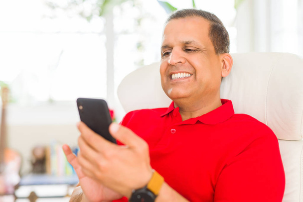 Middle age man smiling cheerful white using smartphone sitting o - Photo, image