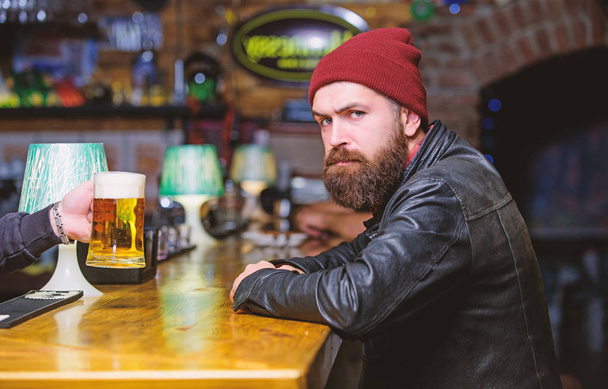 Bar is relaxing place to have drink and relax. Man with beard spend leisure in dark bar. Brutal lonely hipster. Hipster relaxing at bar. Brutal hipster bearded man sit at bar counter. Friday evening - Foto, Imagem