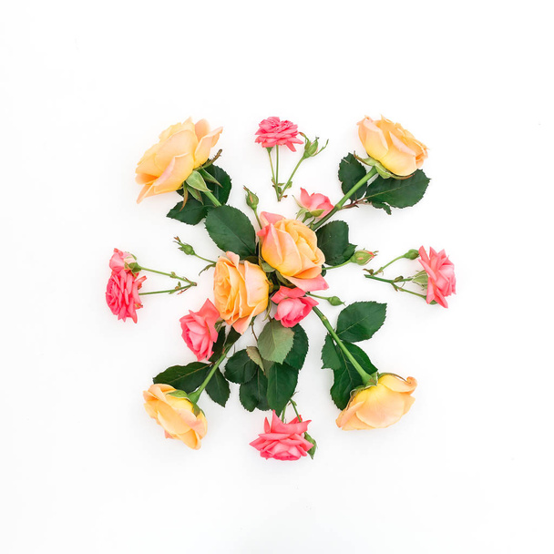 Ροζ και πορτοκαλί τριαντάφυλλα και φύλλα σε λευκό φόντο. Επίπεδη όψη, κορυφή θέα - Φωτογραφία, εικόνα