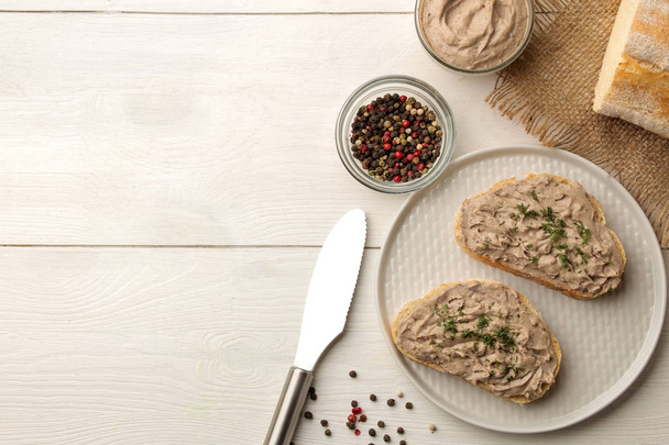 Fresh homemade chicken liver pate with herbs for bread on a white wooden table. A sandwich. top view - Фото, зображення