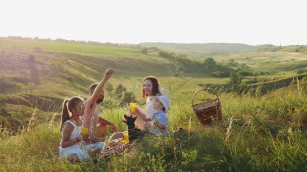 Šťastná rodina na pikniku s miniaturní Pinscherem - Záběry, video