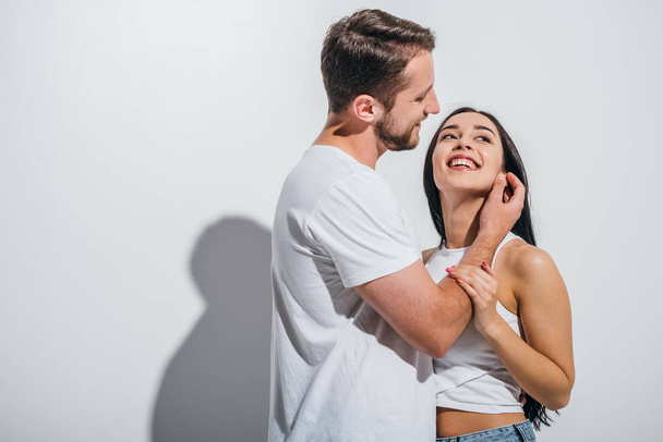 young man readjusting hair of girlfriend while smiling and hugging each other  - Foto, immagini