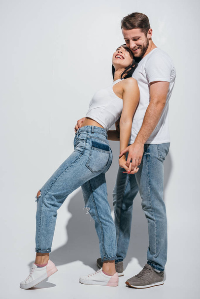 full length view of young couple standing close to each other and holding hands - Fotoğraf, Görsel