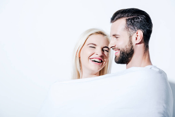girlfriend and boyfriend covered in blanket laughing on white - Fotografie, Obrázek