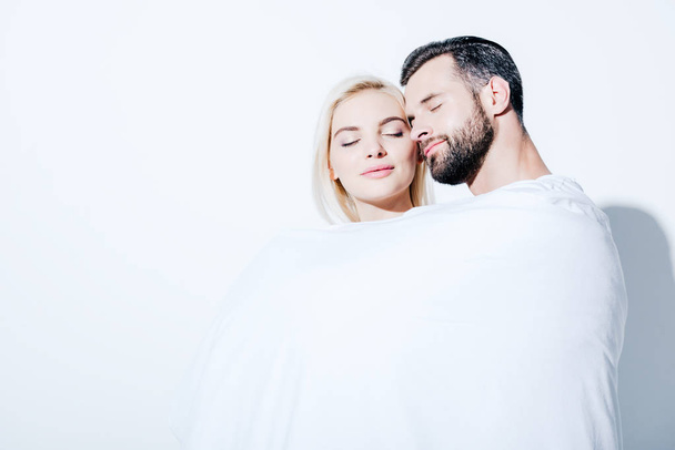 girlfriend and boyfriend covered in blanket with closed eyes on white - Photo, Image