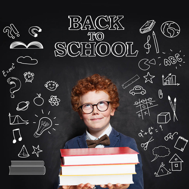 Little child pupil on chalkboard background. Back to school  - Photo, Image