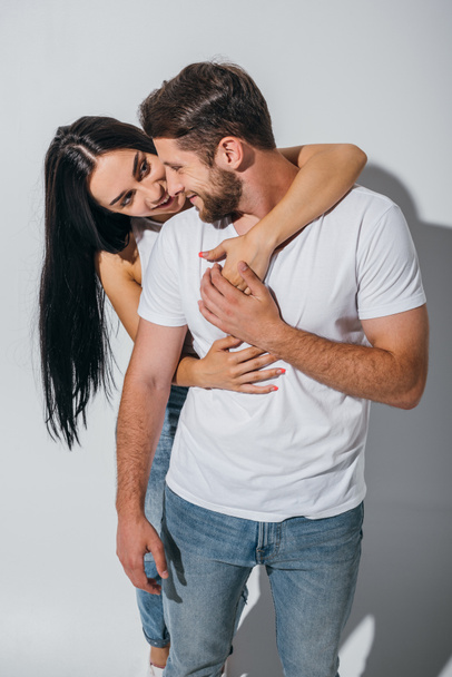 beautiful girl hug boyfriend from back, smiling and looking at guy - Fotografie, Obrázek
