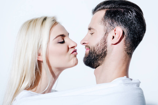 girlfriend pouting lips near boyfriend covered in blanket isolated on white - Foto, Imagem