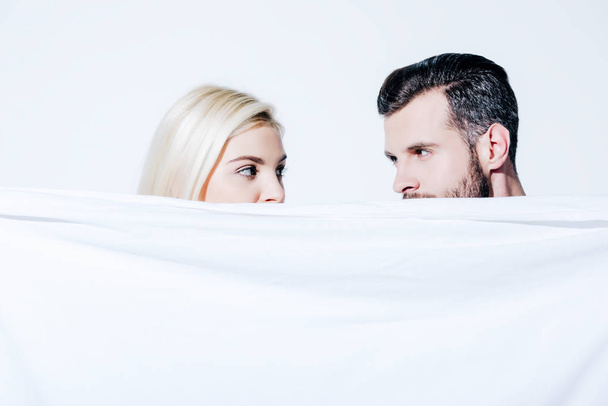Freundin und Freund halten Decke isoliert auf weiß - Foto, Bild