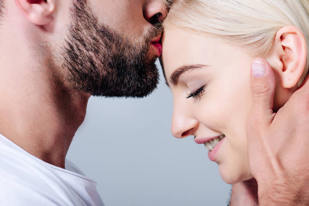 man kissing on forehead beautiful smiling girl isolated on grey - Photo, Image