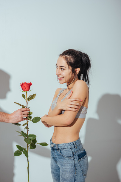 cropped view of man giving red rose to shy girl  - Φωτογραφία, εικόνα