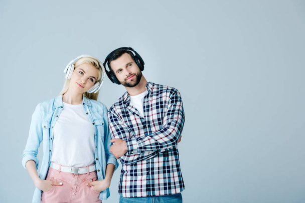 man and girl in headphones isolated on grey with copy space - Foto, Bild