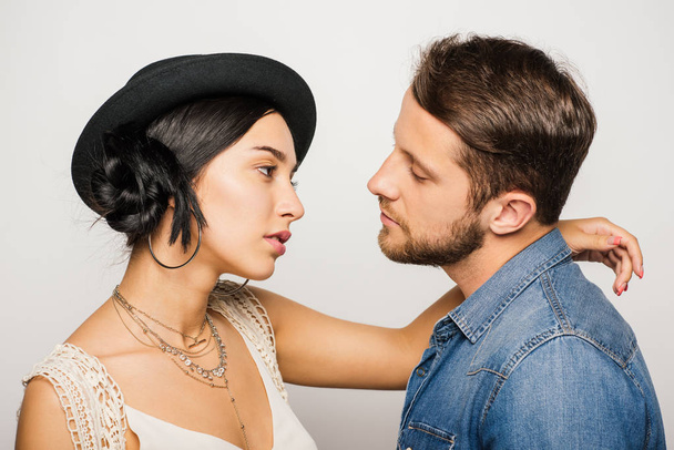 serious beautiful couple in fashionable clothes looking at each other on white background - Fotografie, Obrázek