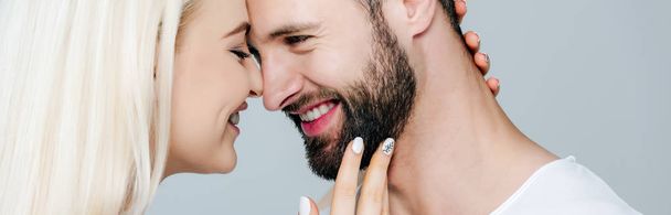 plan panoramique de belle fille embrassant l'homme et souriant isolé sur gris
 - Photo, image