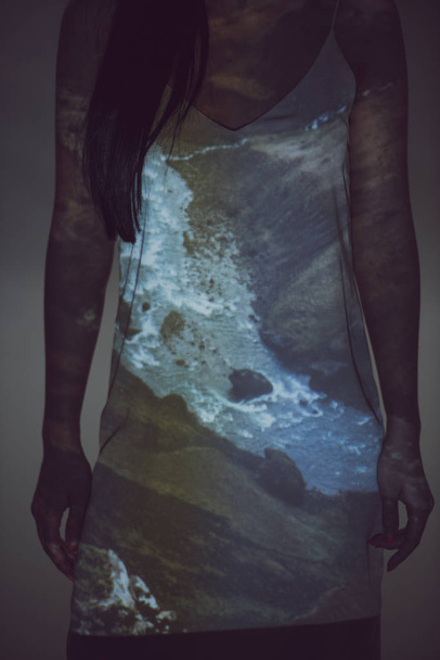 Ausgeschnittene Ansicht einer Frau im Kleid, die in der Dunkelheit steht  - Foto, Bild