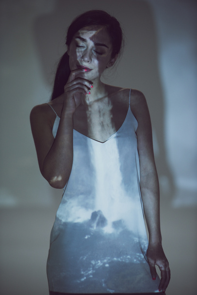 piękna kobieta stojąca w ciemności z zamkniętymi oczami w pozie - Zdjęcie, obraz