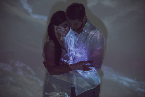 coppia innamorata che si tiene per mano e si abbraccia mentre sta in piedi in luogo buio
 - Foto, immagini