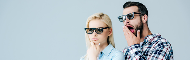 panoramische shot van vervelen man en meisje in 3D bril kijken film geïsoleerd op grijs - Foto, afbeelding