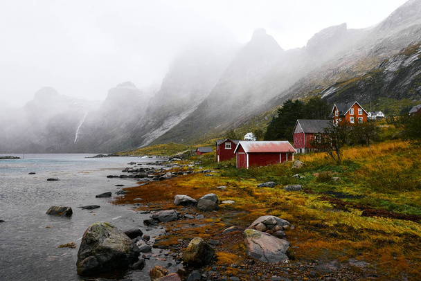Панорамний вид на віддалений старий рибальське село на узбережжі в Vinstad з горами в фоні на Лофотенских островах у Норвегії. - Фото, зображення
