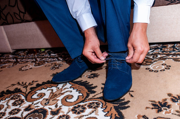 Hombre blanco pone zapatos azul oscuro
 - Foto, Imagen