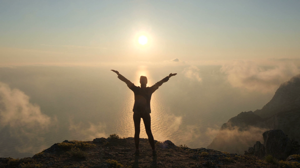 Silhuette Jovem Mulher braços estendidos observando um belo pôr do sol dramático acima de um mar de uma alta montanha na Crimeia
. - Filmagem, Vídeo