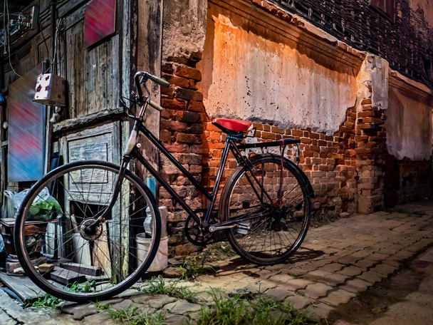 Stare rowery zaparkowane obok starych murów ceglanych. Obok drogi przy  - Zdjęcie, obraz