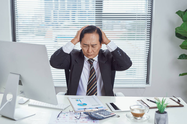 Перевантажений азіатський бізнесмен збирається божевільний в офісі
 - Фото, зображення