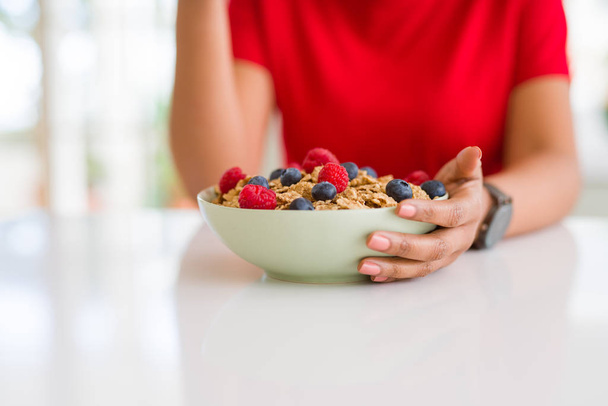 Close up of young woman eating healthy cereals and berries for b - Φωτογραφία, εικόνα