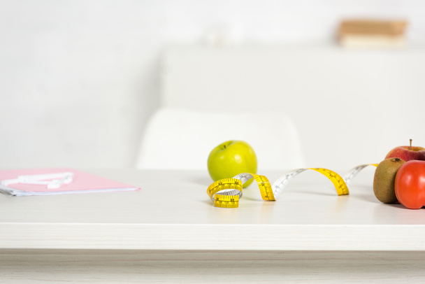 folder, measure tape and fresh food on table - Фото, изображение
