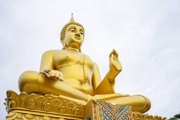 La grande statua di Buddha dorato si erge alto e si distingue ed è
 - Foto, immagini