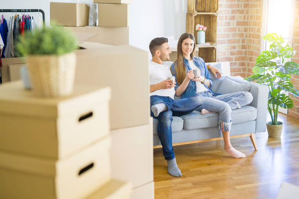 Jovem casal se mudar para uma nova casa relaxante sentado no sofá w
 - Foto, Imagem