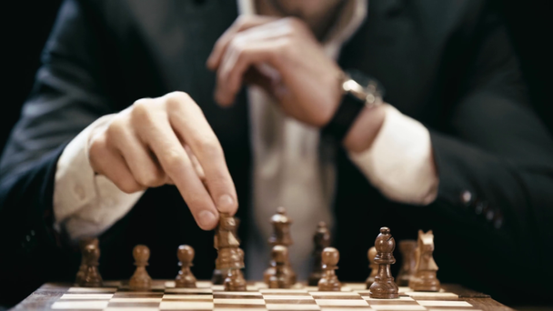 visão parcial do empresário sentado à mesa e jogando xadrez
 - Filmagem, Vídeo