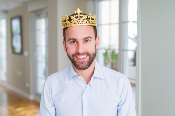 Csinos üzletember visel arany koronát, mint a király vagy a herceg boldog és hűvös mosoly az arcon. Szerencsés ember. - Fotó, kép