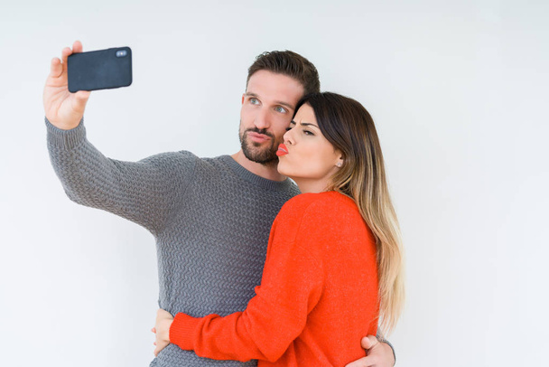 Beautiful young couple in love, kissing and hugging each other taking a selfie picture - Photo, image