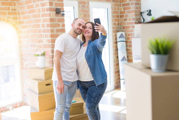 Молода пара робить фотографію за допомогою смартфона в новому будинку
 - Фото, зображення