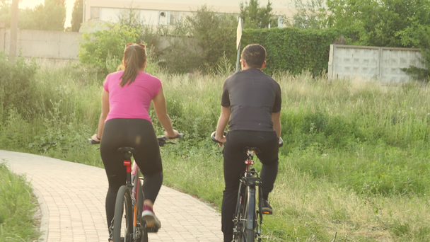 Pár kerékpárosok. Fiatal kaukázusi nő és férfi lovaglás kerékpárok kamera - Felvétel, videó