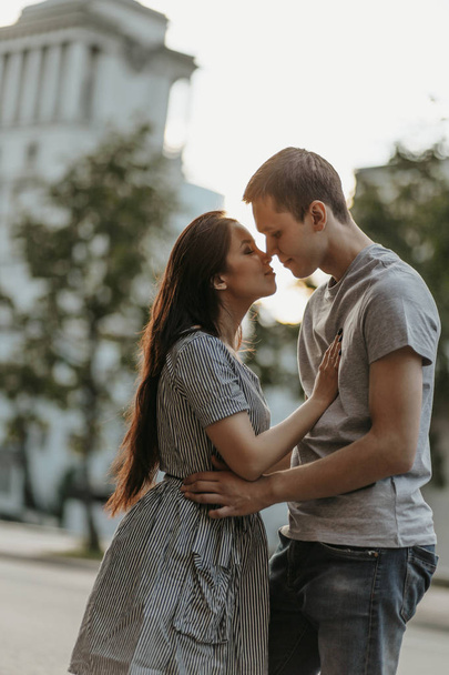 Jeune couple amoureux adolescents habillés dans un style décontracté marchant ensemble et s'embrassant dans la rue de la ville
 - Photo, image