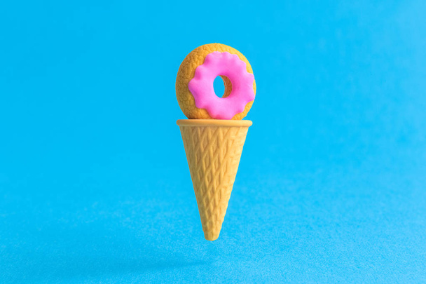 Ice cream cone with doughnut abstract isolated on blue. - Fotoğraf, Görsel