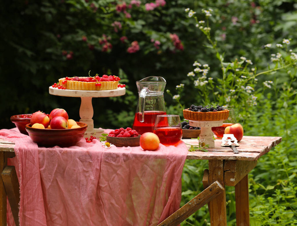 picknick in de natuur, taarten en salades, verse bessen en fruit - Foto, afbeelding