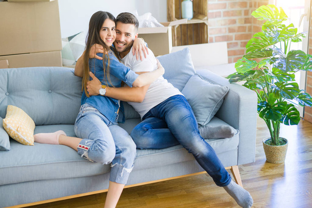 Beautiful couple hugging in love at the sofa, very happy smiling - Photo, Image