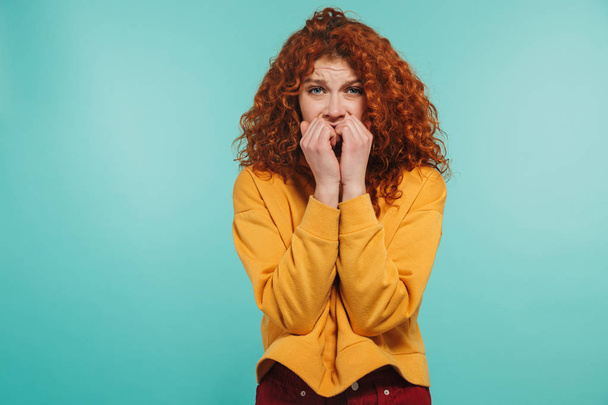 Photo of scared girl 20s with curly ginger hair looking at camer - 写真・画像