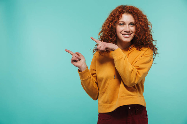 Image of caucasian woman 20s with curly ginger hair smiling and  - Foto, afbeelding