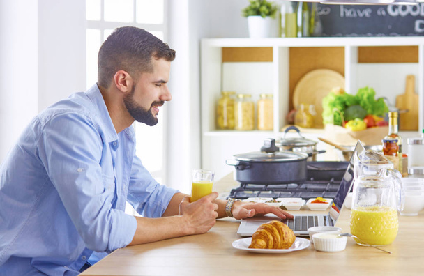 un hombre de negocios desayunos con portátil y jugo
 - Foto, imagen