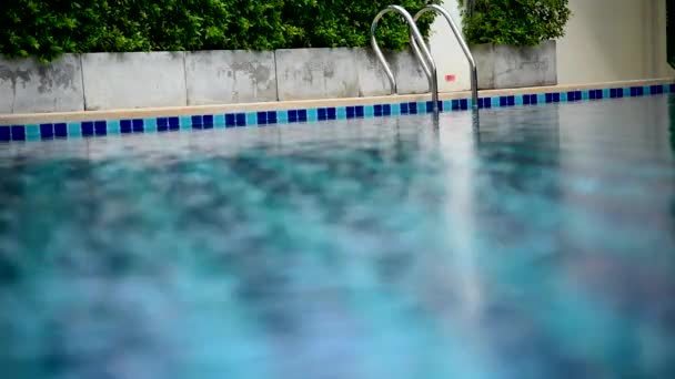 Piscina con escaleras y terraza de madera en un hotel de lujo. piscina azul con agua borrosa
 - Metraje, vídeo