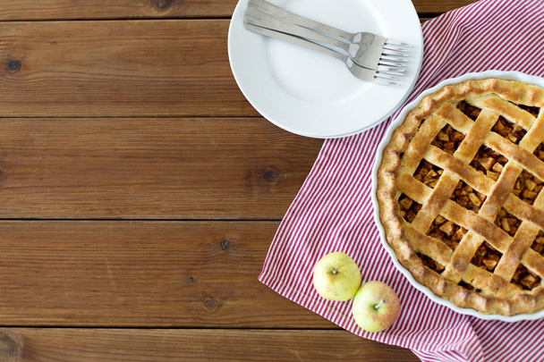 apple pie in baking mold on wooden table - 写真・画像