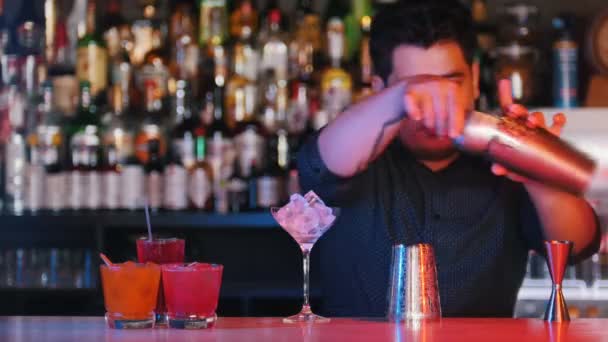 Jonge professionele barman voert barman trucs met een bril - Video